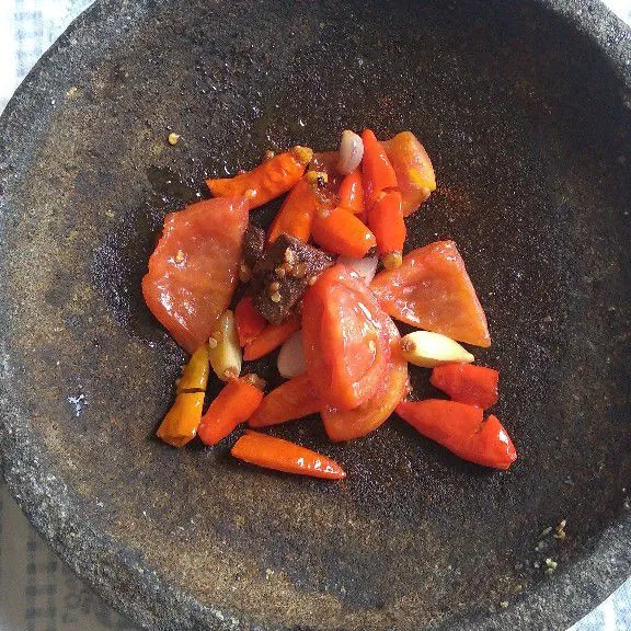 Pindahkan bahan sambal dan terasi ke dalam cobek.