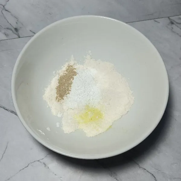 Campur tepung terigu, tepung bumbu serbaguna, dan tepung maizena.  Tambahkan garam, kaldu bubuk, dan lada bubuk.