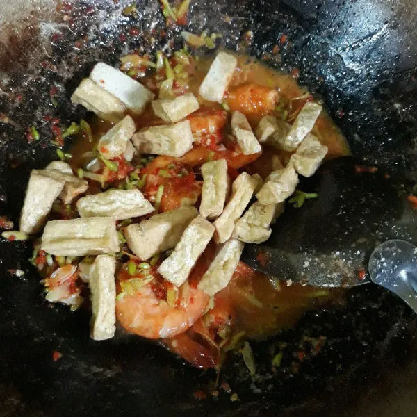 Masukkan tahu goreng dan aduk merata.