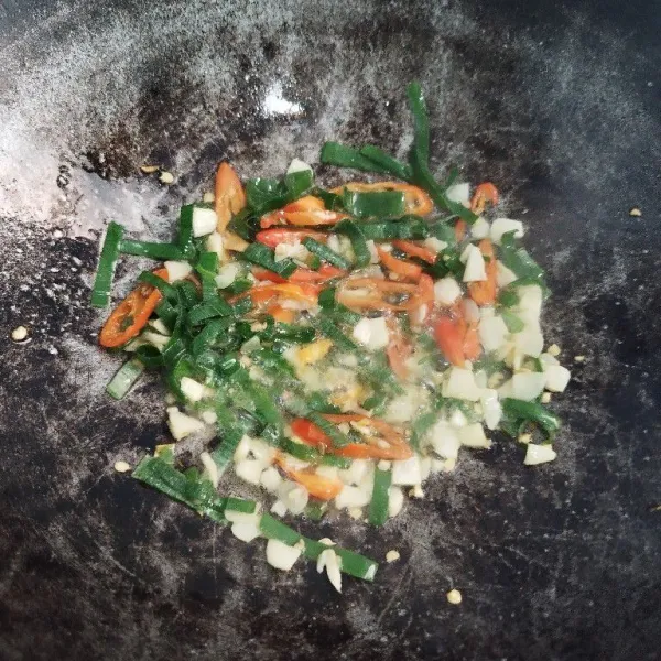 Siapkan wajan masukkan minyak goreng panas makan, masukan cabe, baput dan daun bawang tumis hingga layu.