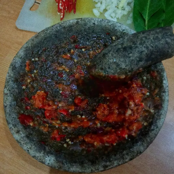 Cincang halus satu siung bawang putih dan iris menyerong satu buah cabe merah. Ulek halus bawang merah, cabe merah besar dan cabe rawit.