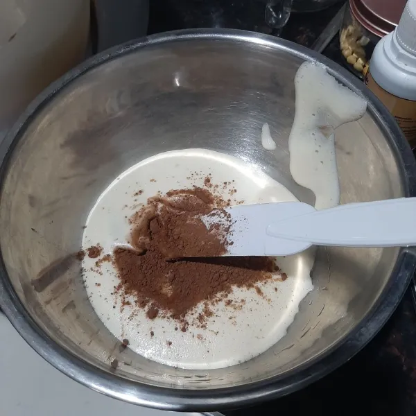 Setelah adonan telur berbusa, pisahkan sekitar ⅓ bagian dan tambahkan bubuk coklat dan vanilla extract.