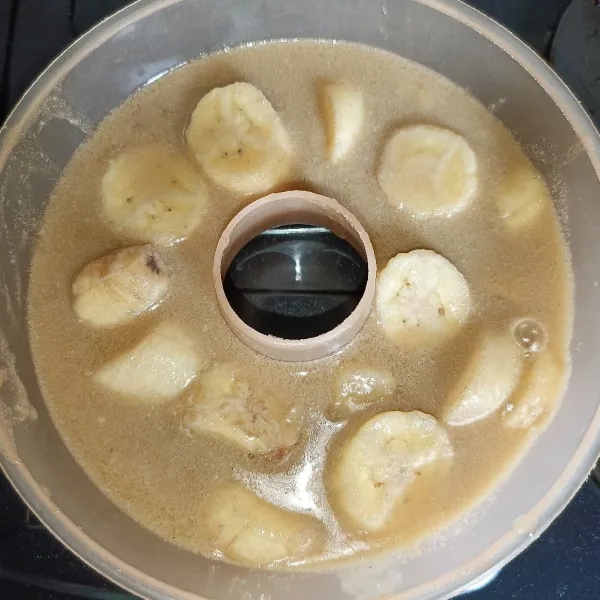 Siapkan cetakan susun semua pisang dan tuang setengah cairan puding, biarkan sampai hampir set