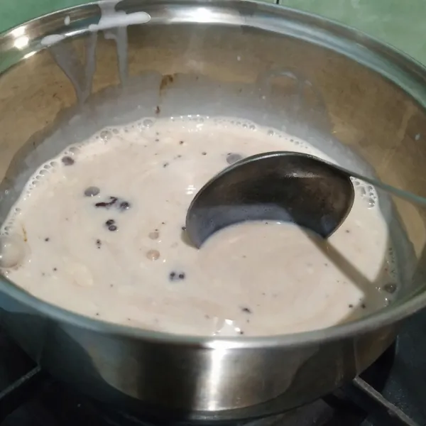 Buat lapisan kedua. Ambil 250 ml bahan utama, tambahkan susu bubuk cokelat dan gula pasir, aduk rata. Nyalakan kompor, masak hingga mendidih. Lalu tuang ke cetakan. Diamkan hingga mengeras. Setelah mengeras, tusuk permukaan pudding dengan tusuk sate.
