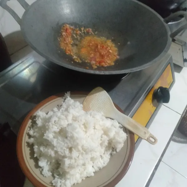 Masukkan nasi, lalu aduk hingga nasi dan bumbu tercampur rata.