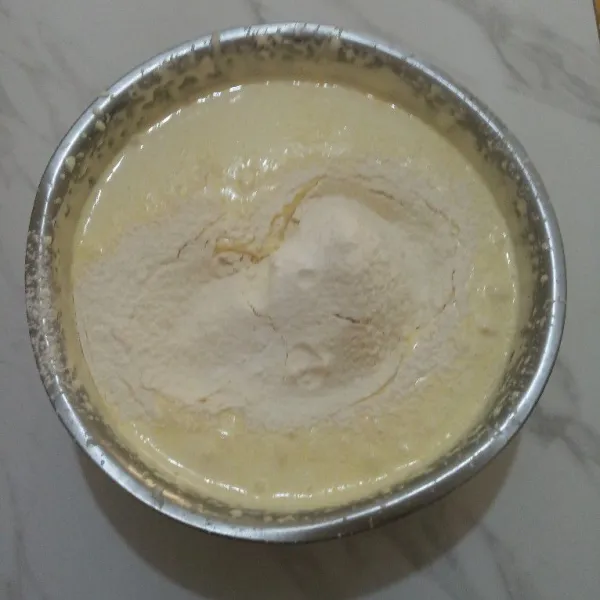 Tambahkan baking powder dan tepung terigu yang sudah diayak. Tuang margarin cair sedikit demi sedikit sambil diaduk rata.