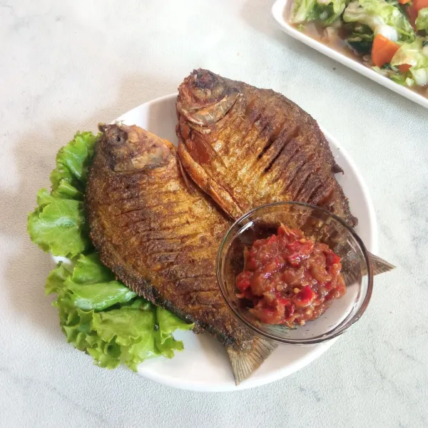 Sajikan ikan bersama sambal terasi dan tambahkan sayuran seperti selada sebagai pelengkap.