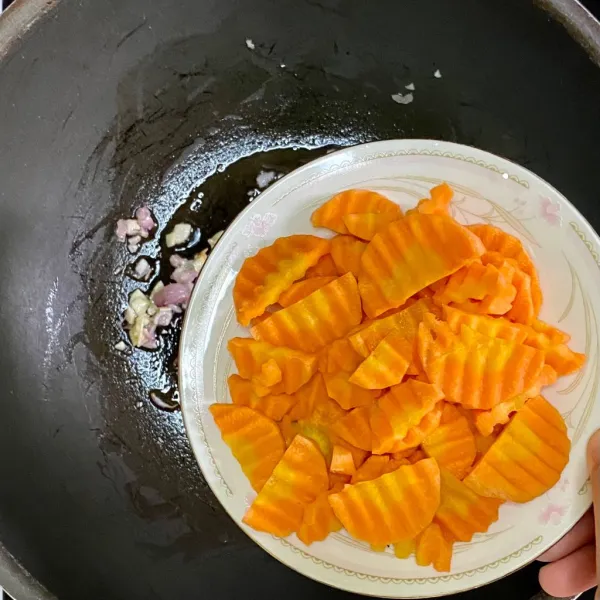 Tambahkan wortel dan air, lalu masak hingga wortel setengah matang.