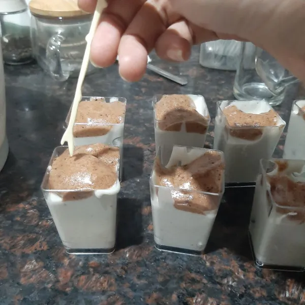 Setelah jadi masukan adonan yogurt puding ke dalam wadah, diikuti adonan coklat lalu buat guratan-guratan agar terbentuk pola di pinggir-pinggir wadah. Dinginkan dan siap sajikan.