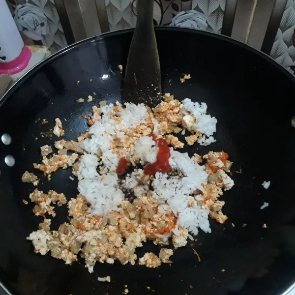 Masukkan nasi, tambahkan garam, kaldu jamur, saus tiram, kecap dan saus cabe. Aduk-aduk sampai semua tercampur dan nasi goreng telah matang.
