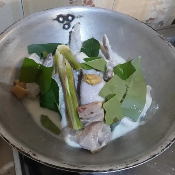 Setelah 1 jam, pindahkan ayam dan bumbu ke dalam wajan. Tambahkan daun jeruk, daun salam, serai, jahe dan lengkuas.