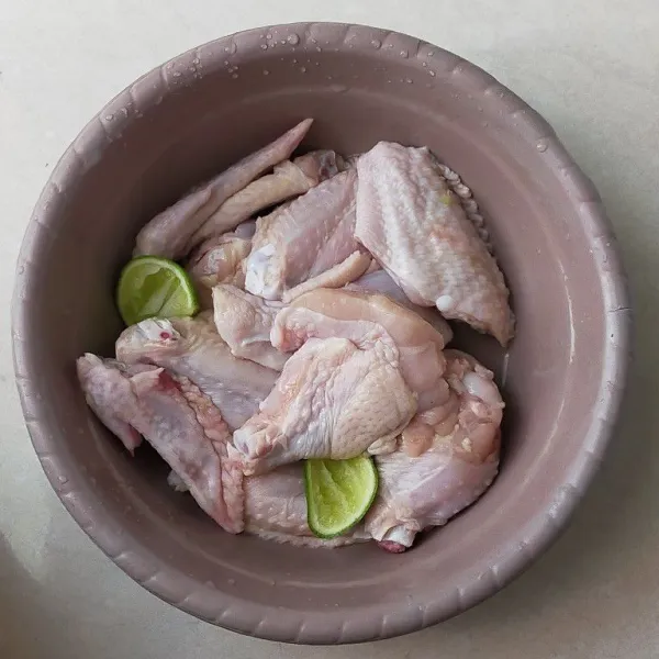 Cuci bersih sayap ayam, kemudian potong jadi tiga bagian, kemudian tiriskan lalu beri air perasan jeruk nipis kemudian diamkan selama 10 menit.