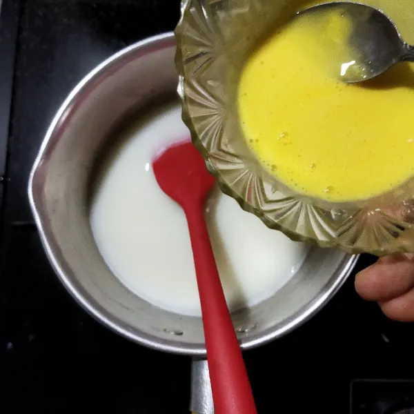 Campurkan 2 butir kuning telur dengan larutan tepung maizena, kocok hingga tercampur rata. Tambahkan kocokan kuning telur ke dalam susu hangat secara perlahan (sambil diaduk).