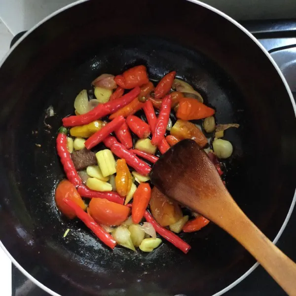 Goreng cabai rawit, cabai merah keriting, tomat merah, bawang merah, bawang putih dan terasi sampai matang.