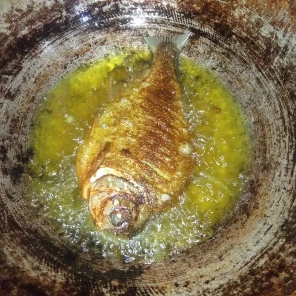 Panaskan minyak, goreng ikan hingga kedua sisinya matang lalu angkat dan tiriskan.