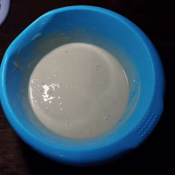 Tuang susu cair sedikit demi sedikit sambil diaduk hingga rata dan licin.