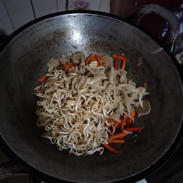 Masukkan tauge dan jamur tiram lalu bumbui garam dan kaldu bubuk. Masak hingga layu.