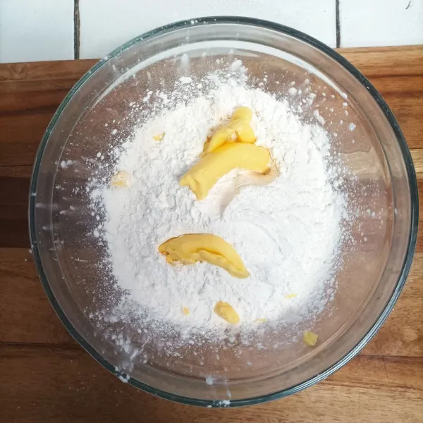 Campur semua bahan tepung, beri garam, gula halus, dan mentega. Aduk-aduk hingga membentuk buliran