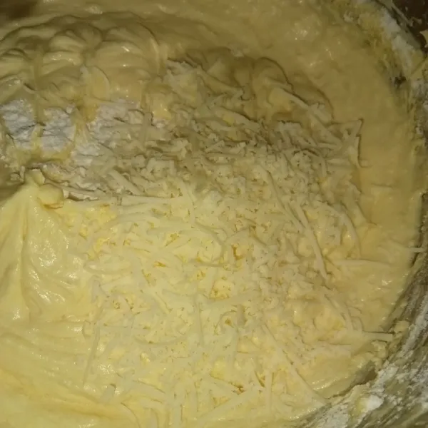 Masukkan tepung bergantian dengan keju parut.