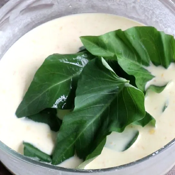 Masukkan daun kangkung ke dalam adonan tepung.