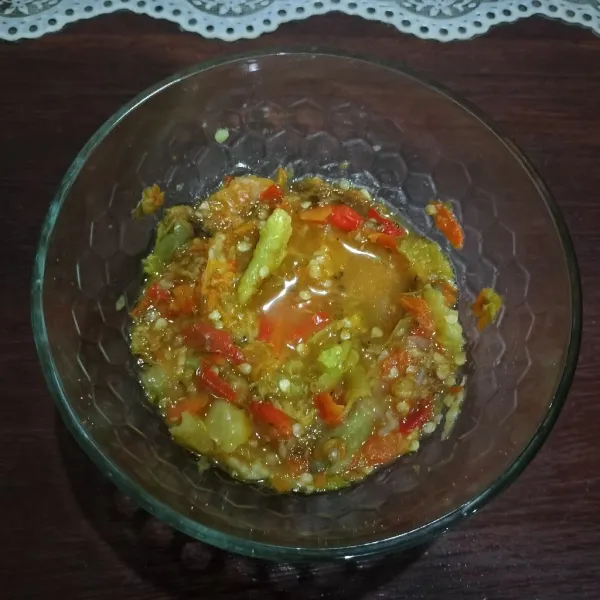 Untuk membuat sambal, rebus cabai rawit dan bawang putih. Haluskan kasar, lalu siram dengan sedikit kuah soto.