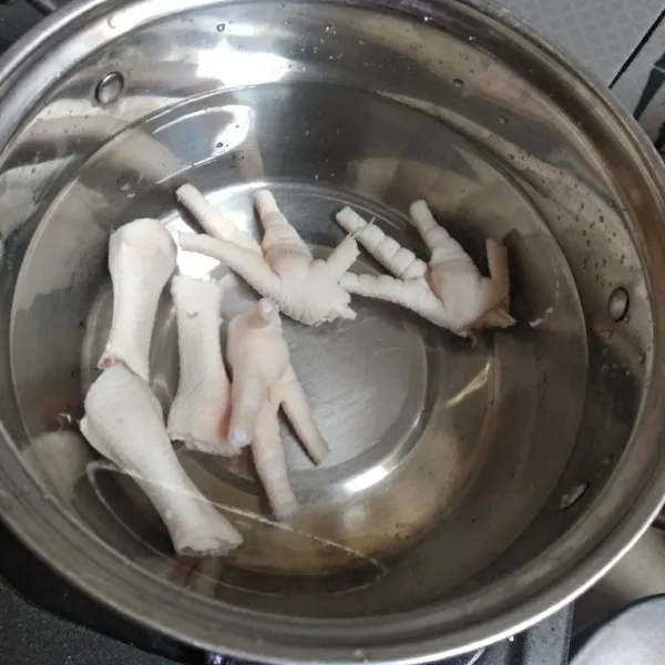 Potong menjadi dua ceker ayam lalu rebus kurang lebih selama 15 menit.