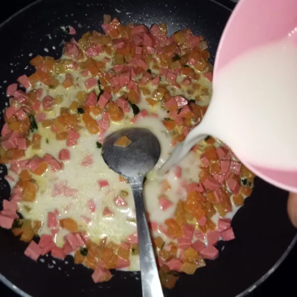 Tumis bumbu dasar putih hingga harum, masukkan sosis dan wortel. Aduk rata dan tambahkan susu cair, tepung terigu, lada, gula, dan garam.