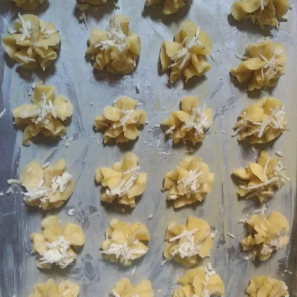 Cetak dengan piping bag adonan tadi, sebelumnya alas untuk mengoven sudah di oles mentega. Kemudian cetak adonan sampai habis. Beri taburan keju di atasnya. Oven sampai matang. Dinginkan dalam suhu ruang. Jika sudah dingin masukkan dalam toples kedap udara