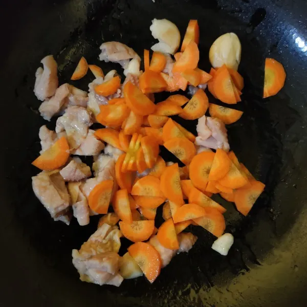 Masukkan ayam dan wortel, masak hingga berubah warna.