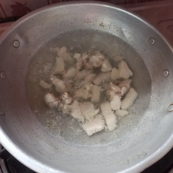 Potong dadu ayam kemudian rebus hingga matang, setelah itu angkat dan tiriskan.