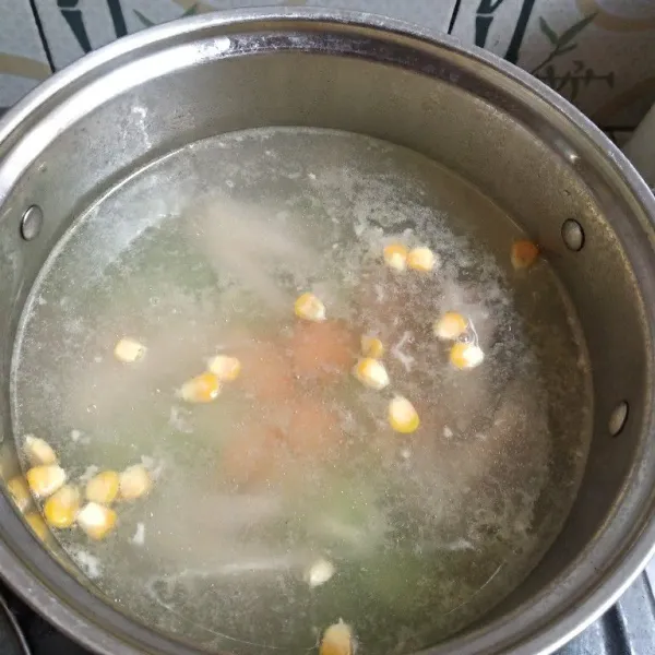 Masukkan potongan wortel, jagung dan labu. Masukkan juga kaldu bubuk lalu masak sampai sayuran matang.