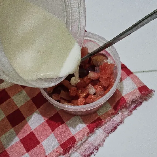 Untuk membuat eskrim yogurt, potong kecil-kecil semangka dan anggur, kemudian campurkan dengan yogurt.