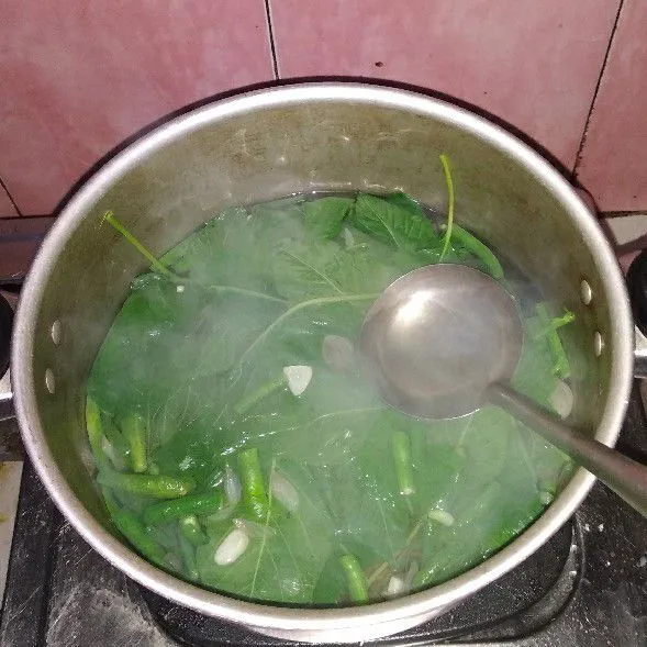 Tambahkan bayam, dan biarkan hingga bayam agak layu.