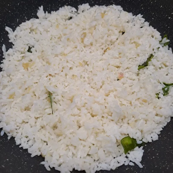 Masukkan nasi putih, aduk rata dengan bumbu.