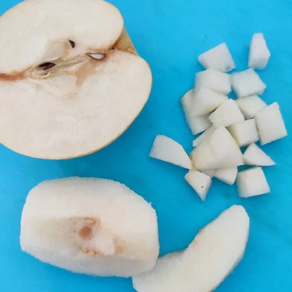 Cuci bersih buah pear, kupas kulitnya dan potong dadu.