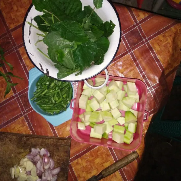 Siapkan semua bahannya. Kupas dan potong-potong blustru dan kacang panjang sesuai selera. Kemudian siangi bayam. Iris tipis bawang merah dan bawang putihnya.