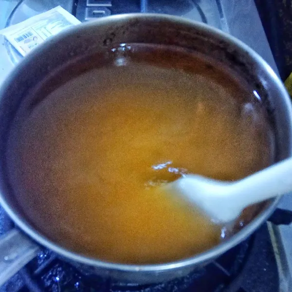 Lanjut memasak jelly jeruk. Campur jelly bubuk rasa jeruk, sisa gula pasir dan air, aduk rata. Masak sambil terus diaduk hingga mendidih. Matikan api kompor.