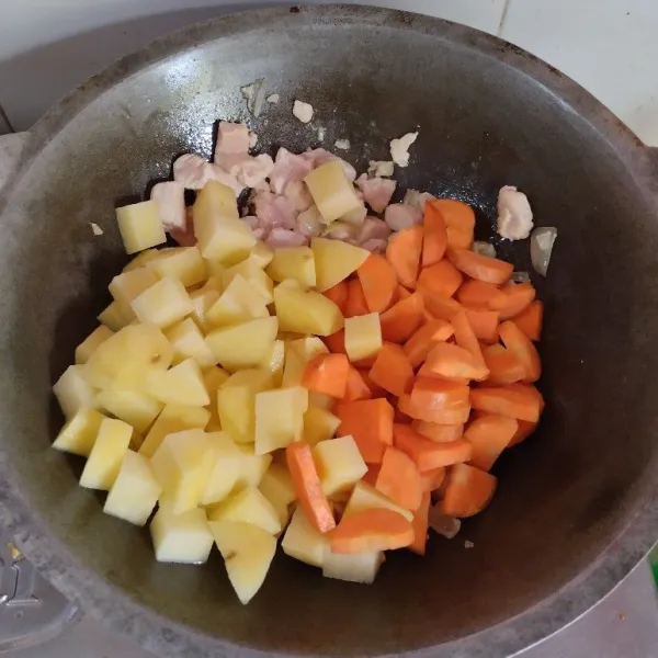 Masukan kentang dan wortel, aduk dan tambahkan air tunggu sampai mendidih dan empuk.