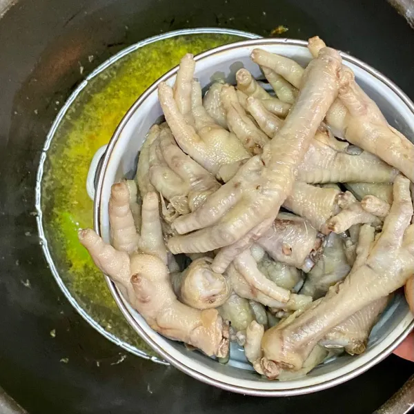 Tambahkan air dan ceker ayam, lalu didihkan.