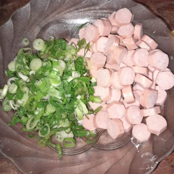 Potong-potong sosis sesuai selera. Daun bawang diiris tipis, bahan ini akan jadi isian nantinya.