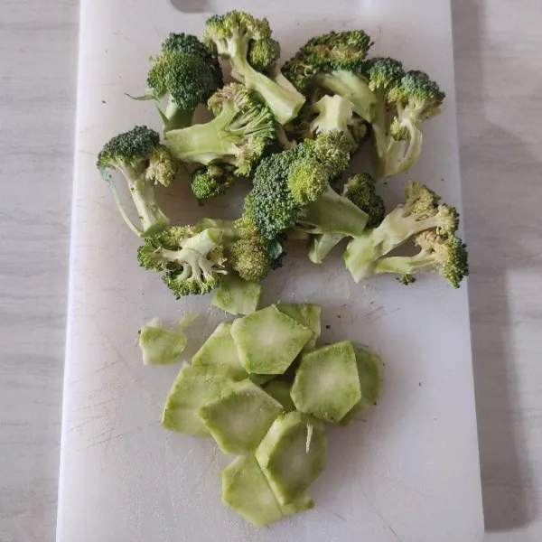Potong kecil kuntum brokoli, lalu kulit batang brokoli di kupas dan di iris.