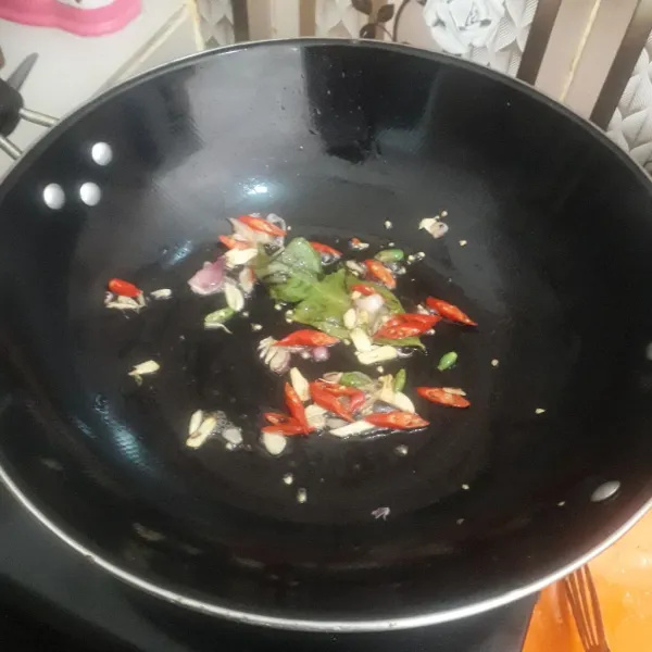 Panaskan minyak goreng dalam wajan. Masukkan bumbu iris. Masukkan daun salam. Tumis sampai  harum. Tambahkan sedikit air.