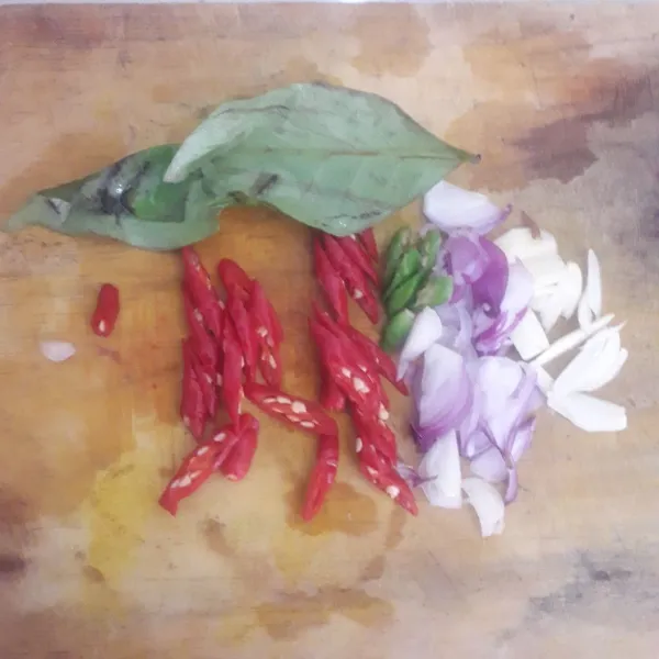 Siapkan bumbu. Iris-iris bawang merah dan bawang putih. Cuci dan iris serong cabe.