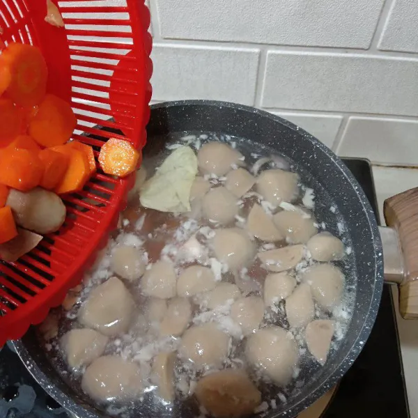 Setelah mendidih, tambahkan bakso dan wortel. Rebus kembali hingga mendidih 2x dan bakso mekar.