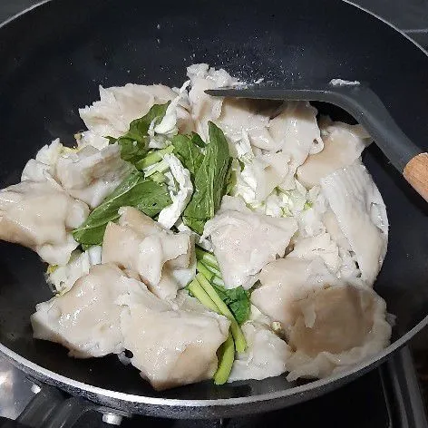Masukkan pangsit, sawi, dan kubis. Aduk rata.