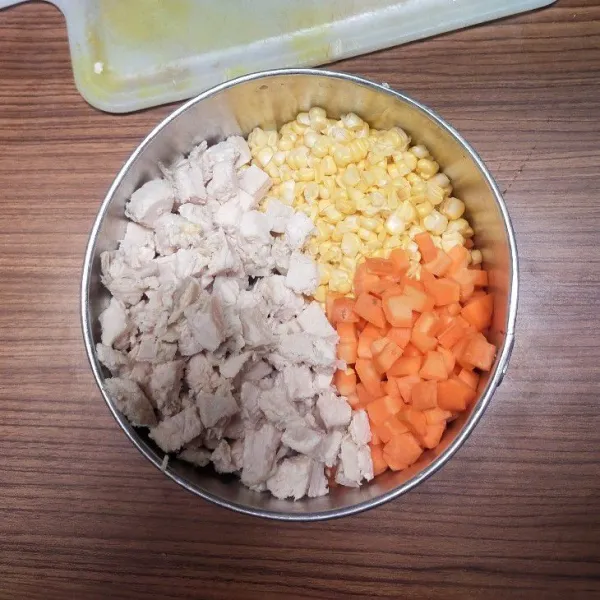 Rebus dada ayam lalu potong-potong kotak, wortel, dan jagung.
