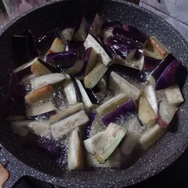 Kemudian goreng terong sampai setengah matang.