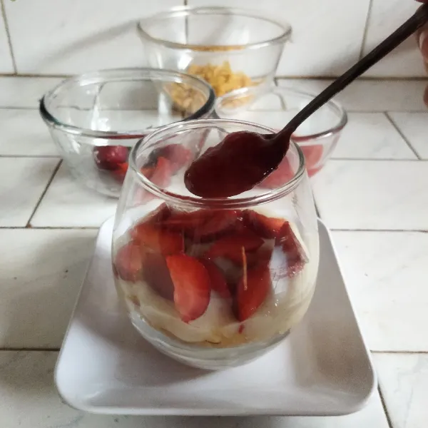 Tuangkan potongan buah strawberry dan selai strawberry.