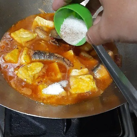 Masukkan tahu kemudian tambahkan garam, gula, kaldu, dan lada bubuk. Aduk rata.