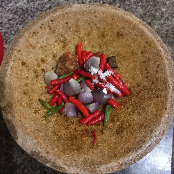 Tambahkan garam, gula merah dan terasi bakar pada cobek.